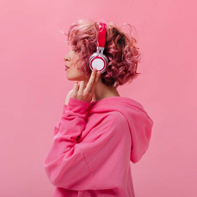 portrait curly pink haired woman massive white headphones e1686861052100